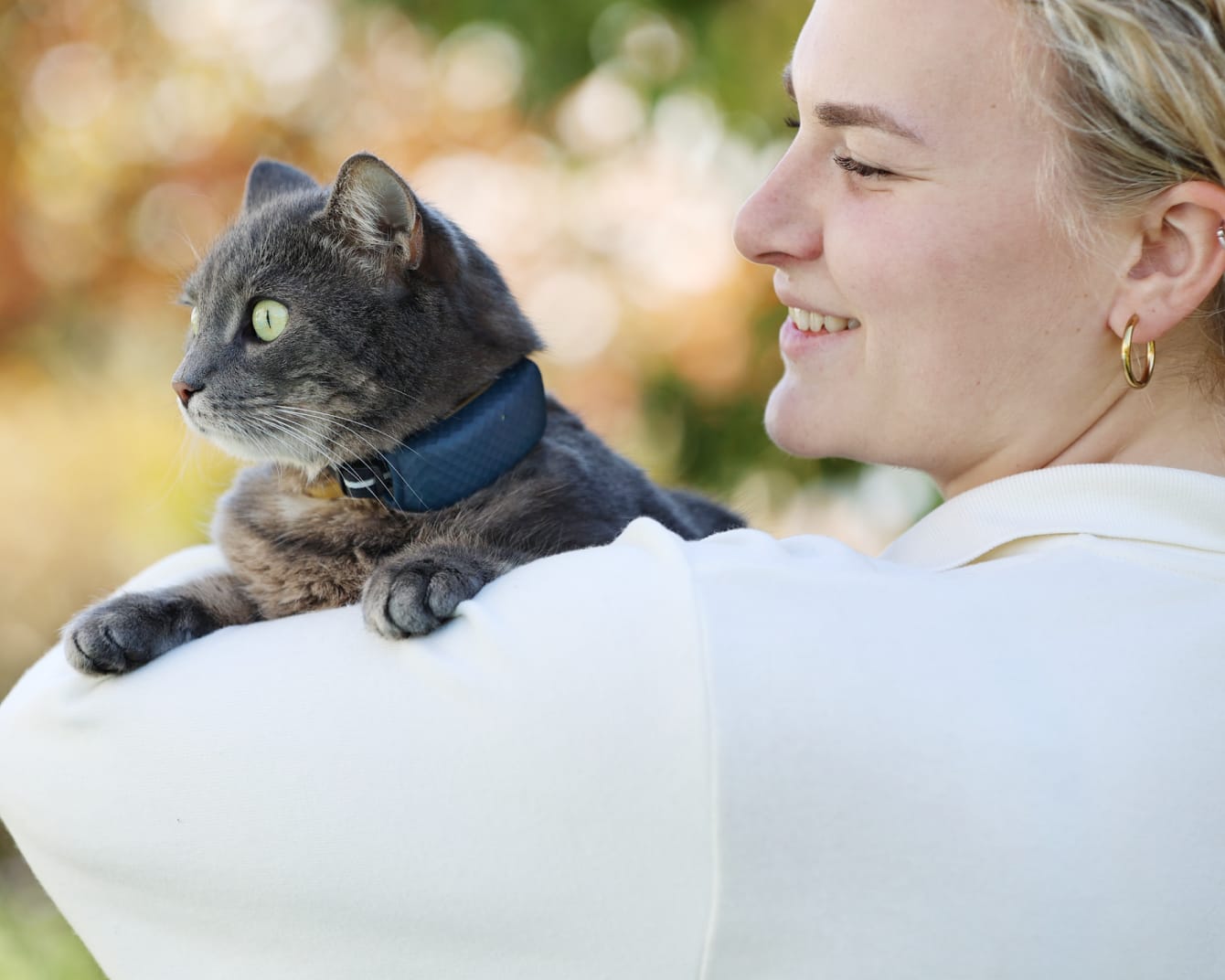Ägare som håller katt med GPS-tracker