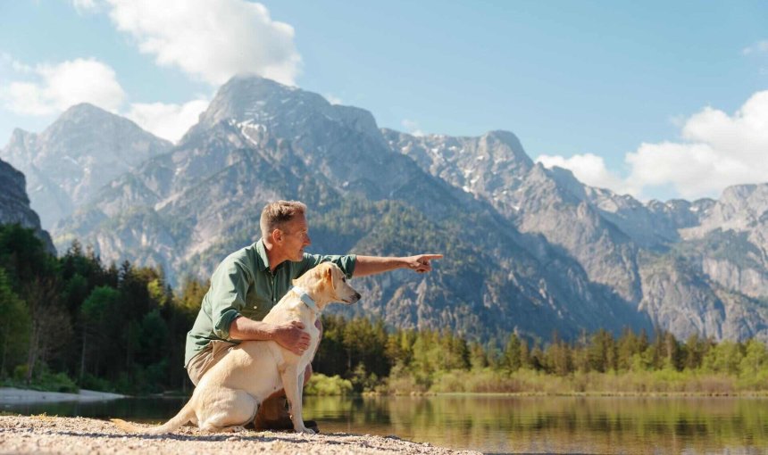 A man with a dog that's wearing a Tractive GPS tracker