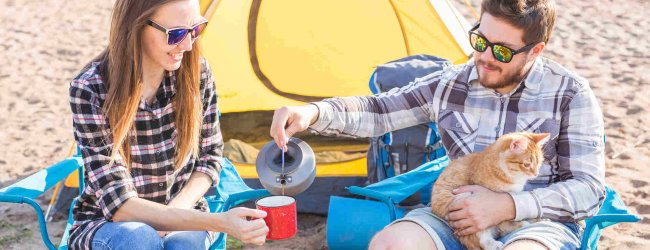 two people camping with a cat