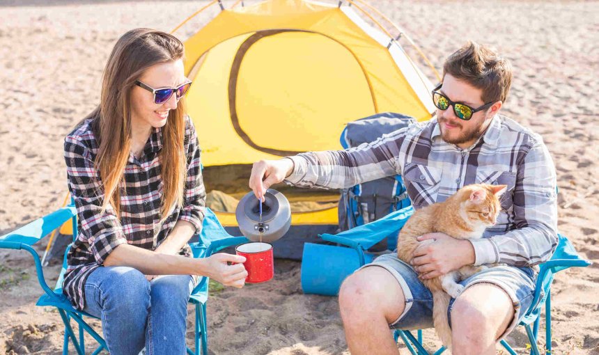 two people camping with a cat