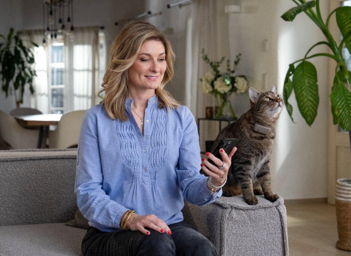 Woman on sofa with cat - pet tracker smart home device Integration