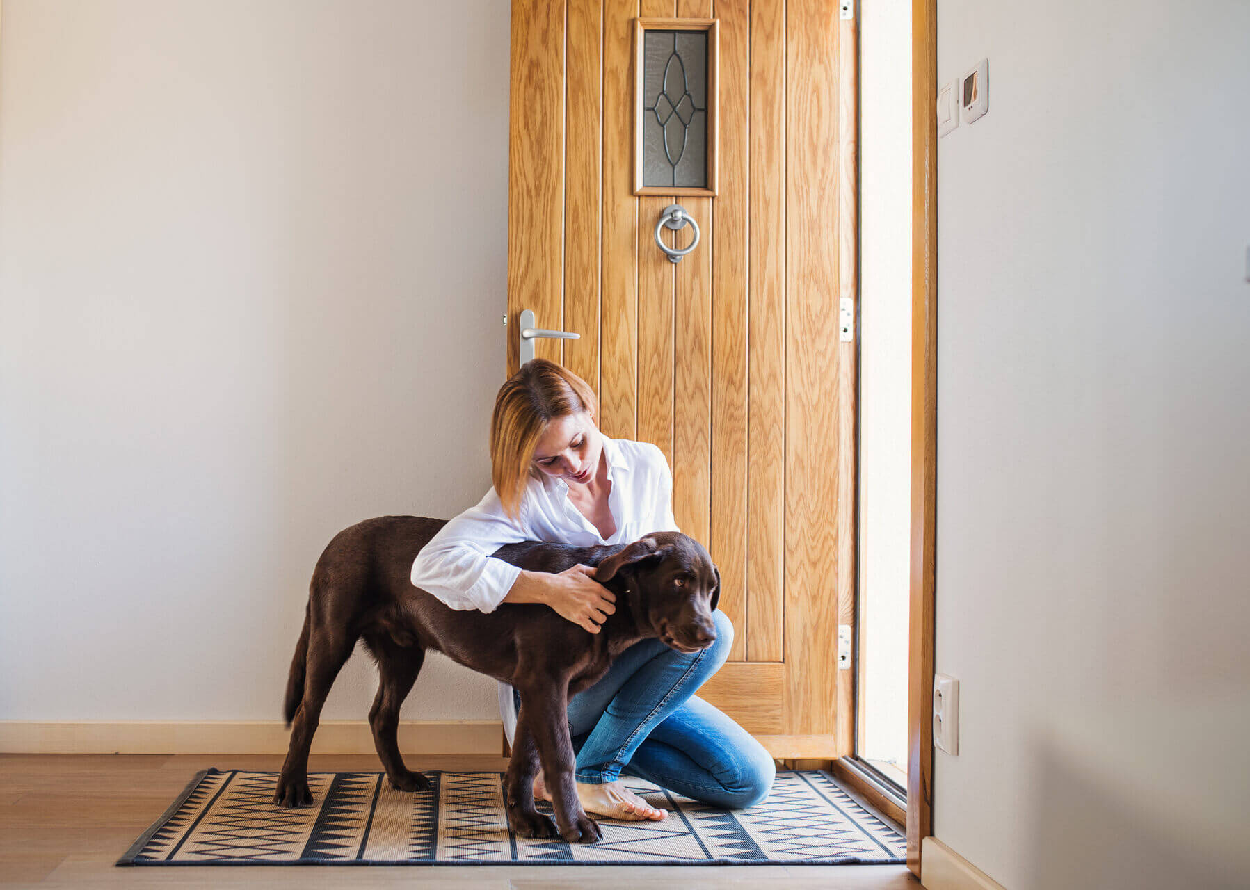 A woman comforting a dog with separation anxiety