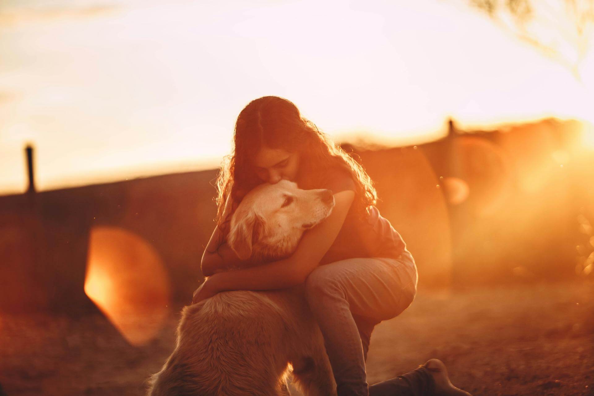 A woman hugging a dog outdoors