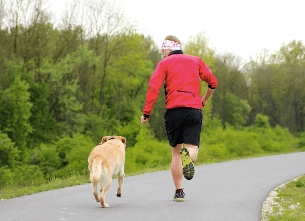 Man springer med hund utomhus