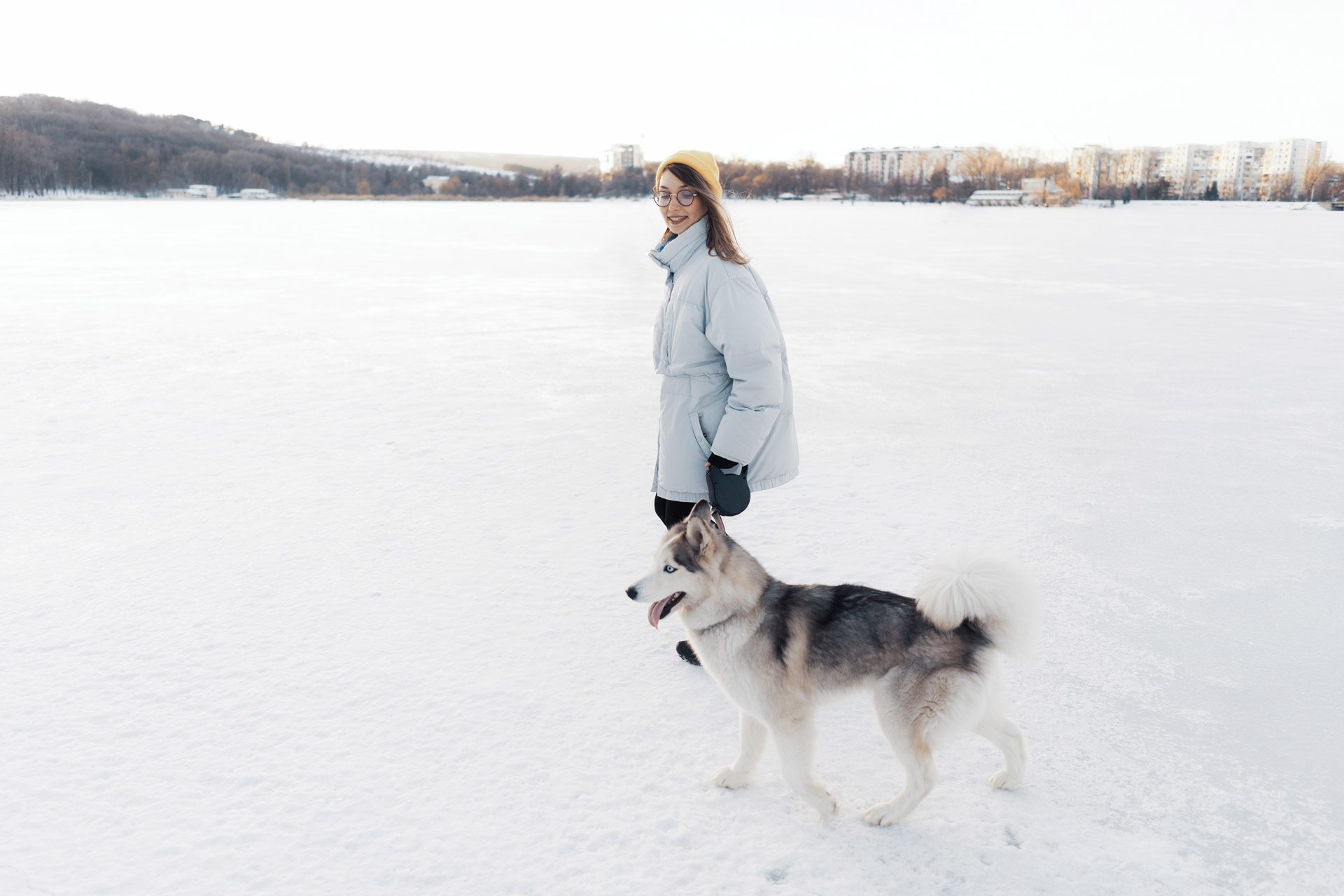 A woman walking her dog in the snow