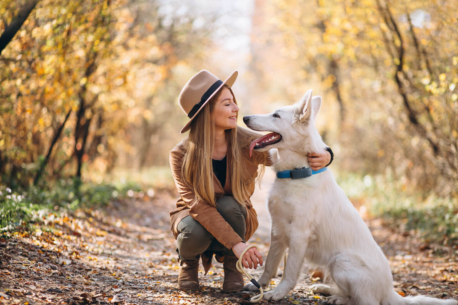 kvinna i skog med hund som har Bluetooh hund-GPS från Tractive