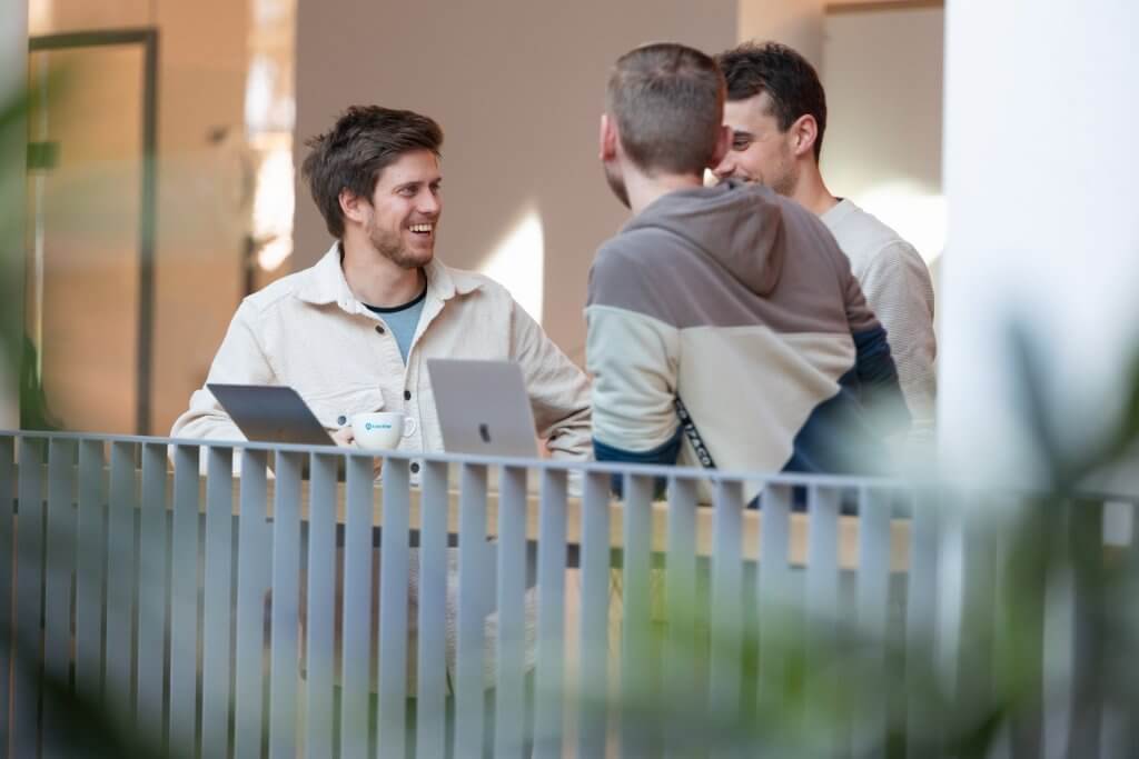 three men in an office talking
