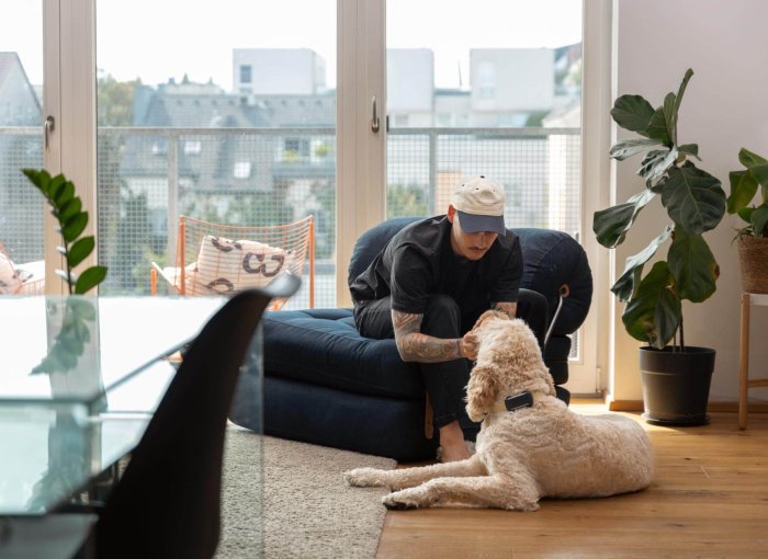 Mann streichelt Hund im Haus