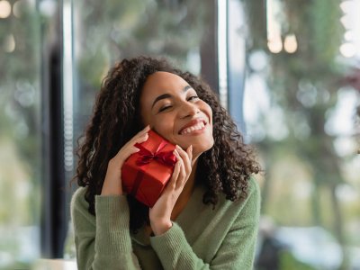 woman holding small red gift-wrapped present