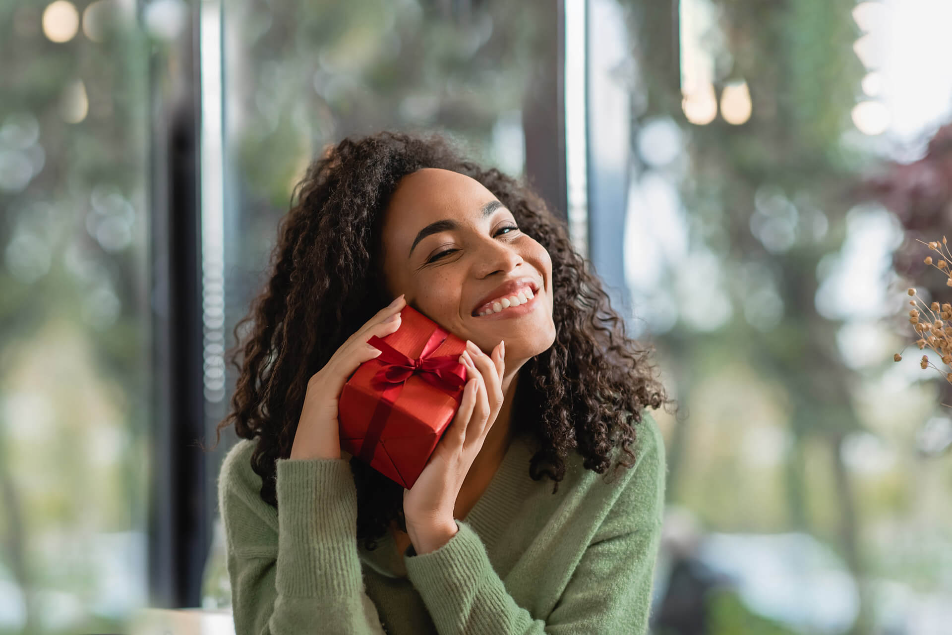 woman holding small red gift-wrapped present