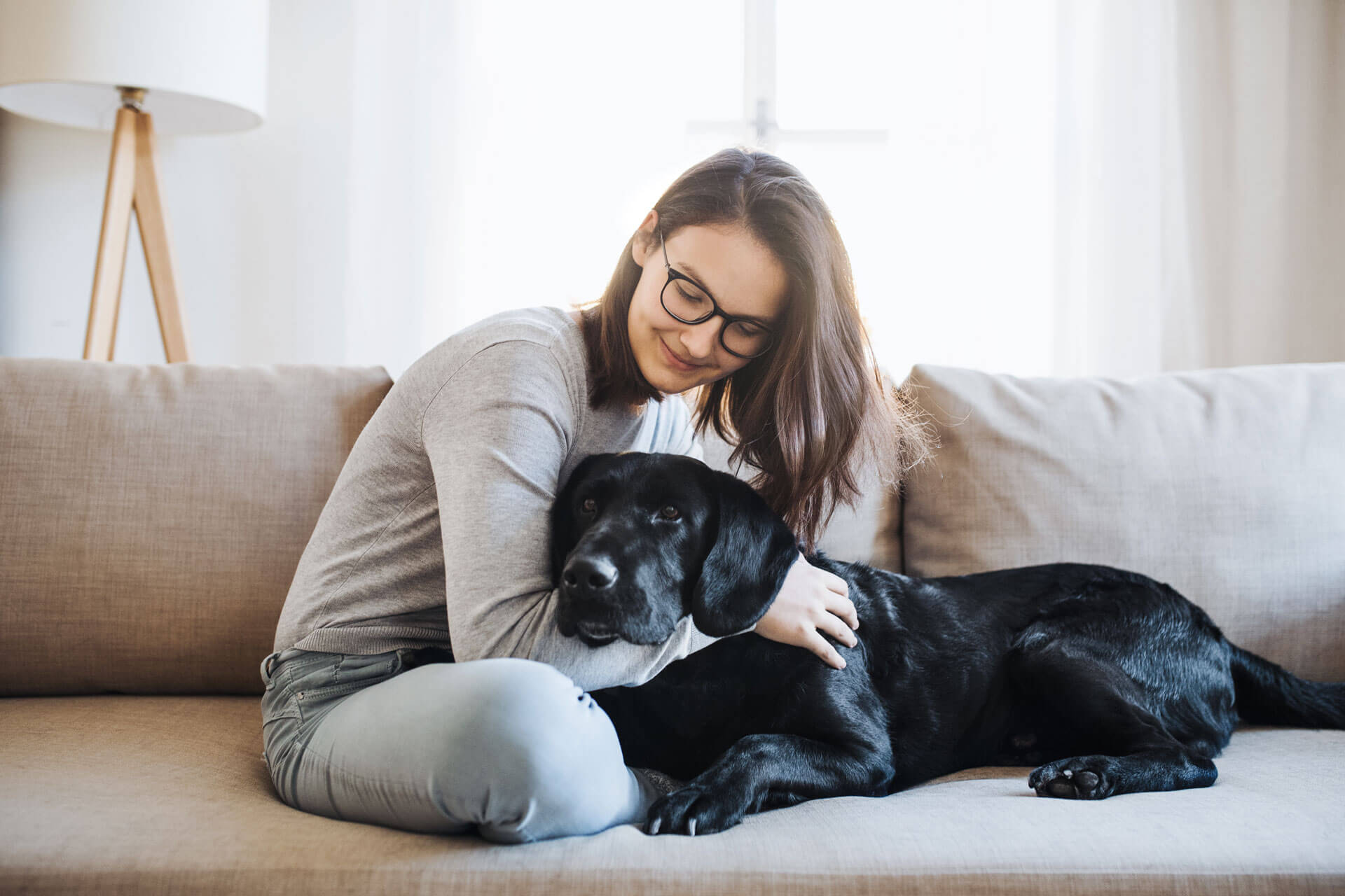 young woman with black dog on couch
