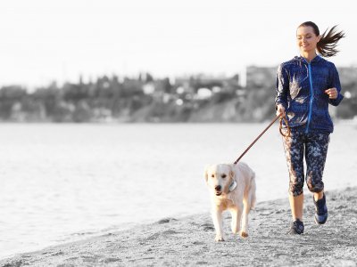 Woman running outdoors with dog on leash