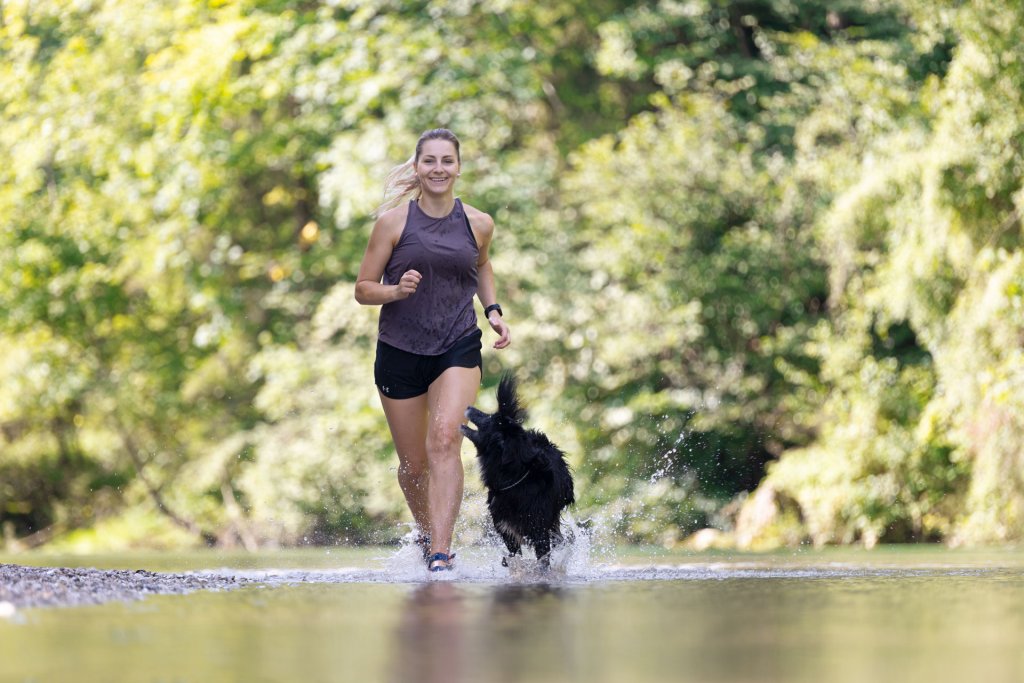 donna che corre all'aperto con il cane