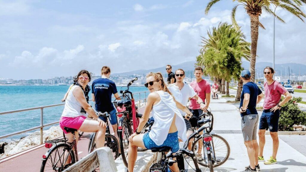 group of men and women on bikes near the beach