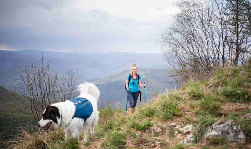 Donna che fa un'escursione con il suo cane senza guinzaglio.