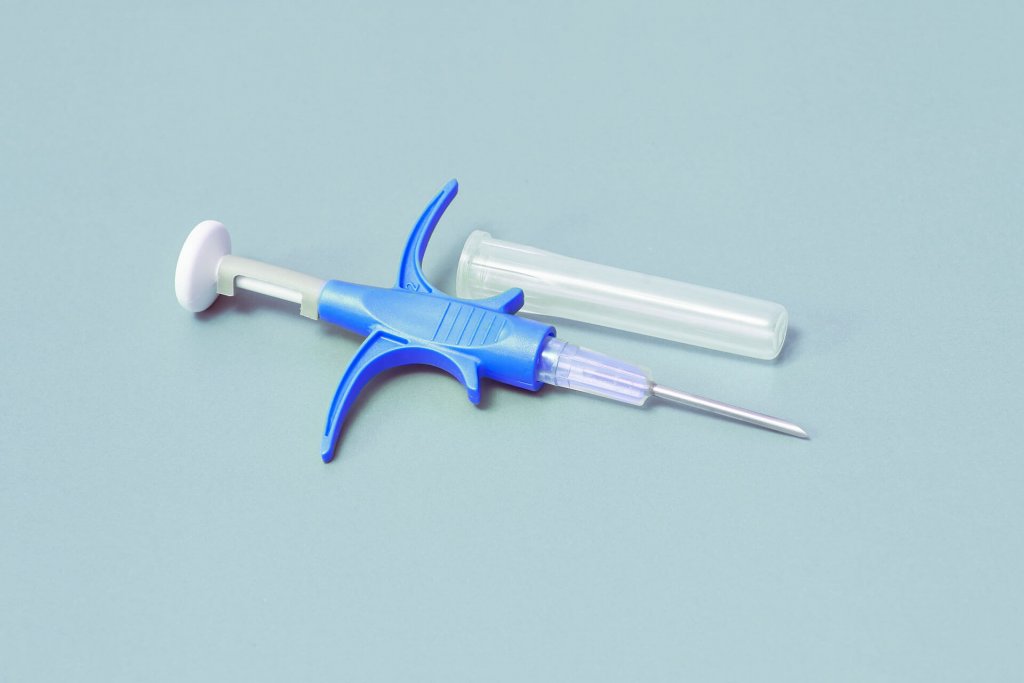seringue bleue servant à injecter une puce d'identification pour chien, sur un fond gris