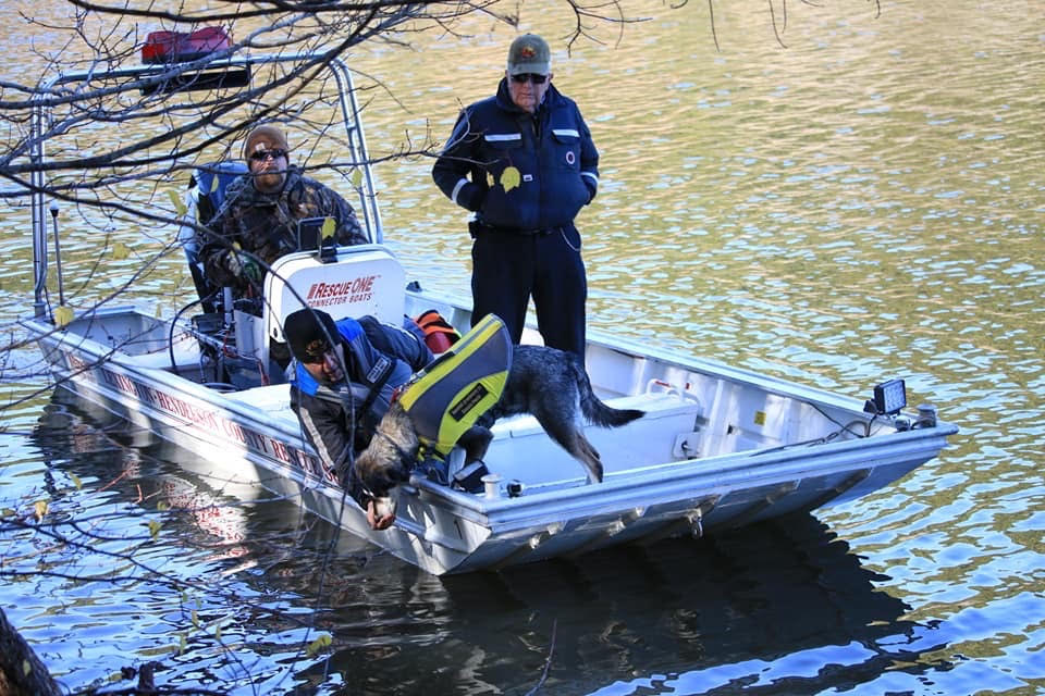 Suchhund und Menschen auf einem Boot während einer Such- und Rettungsaktion