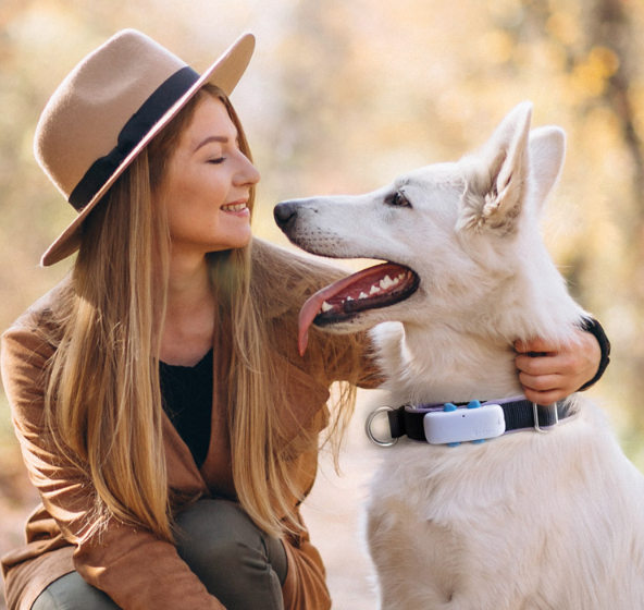 A woman hugging her dog who is wearing a Tractive GPS on their collar