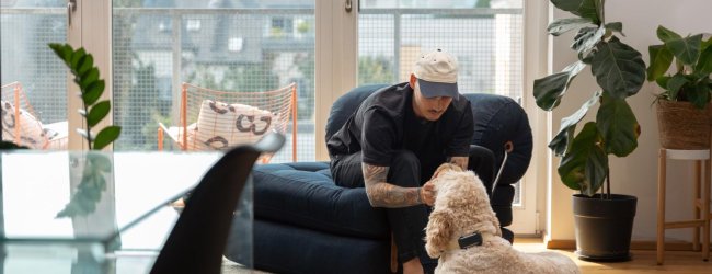 Un homme se préparant à laisser son chien seul à la maison.