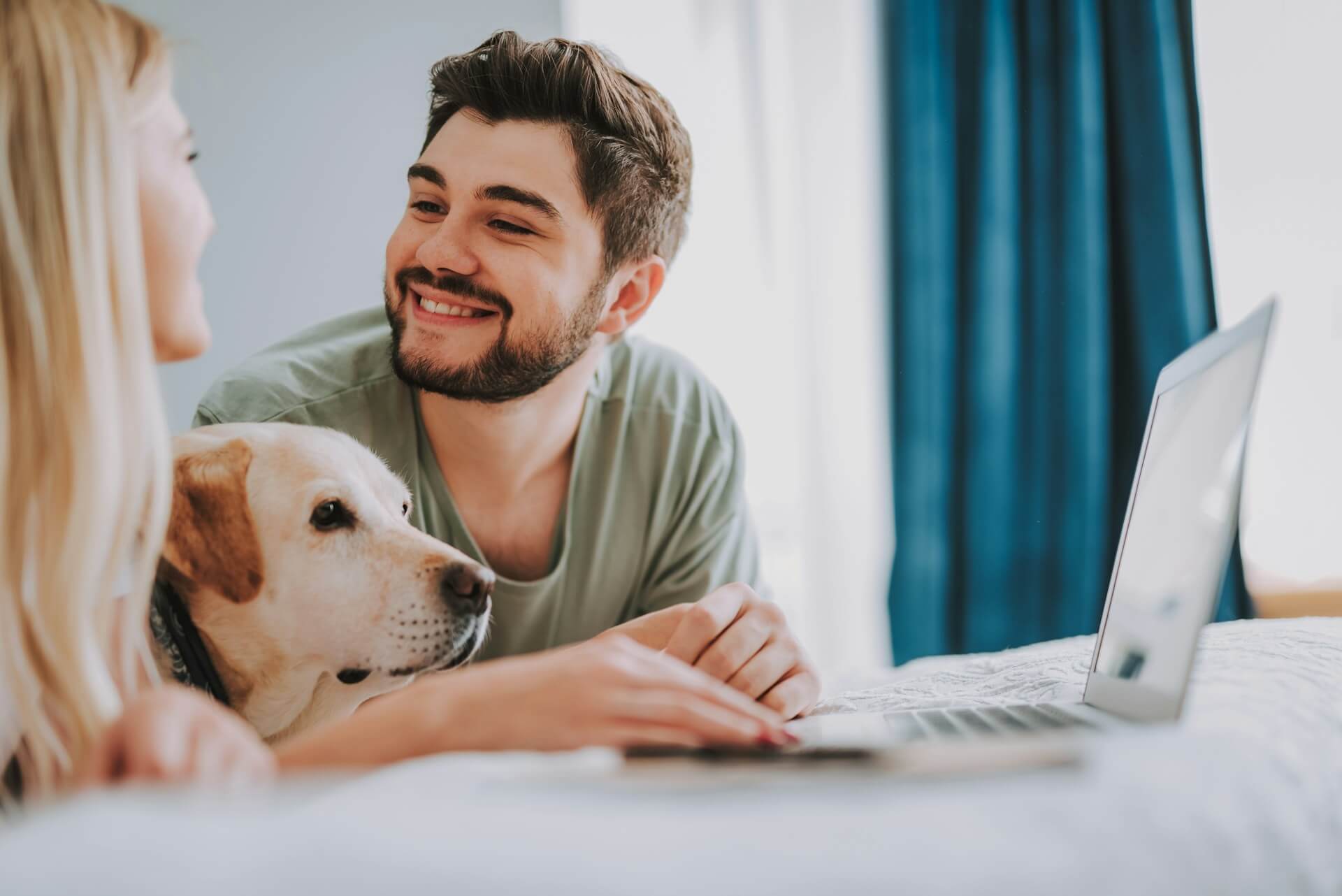 A couple checking insurance plans online along with their dog