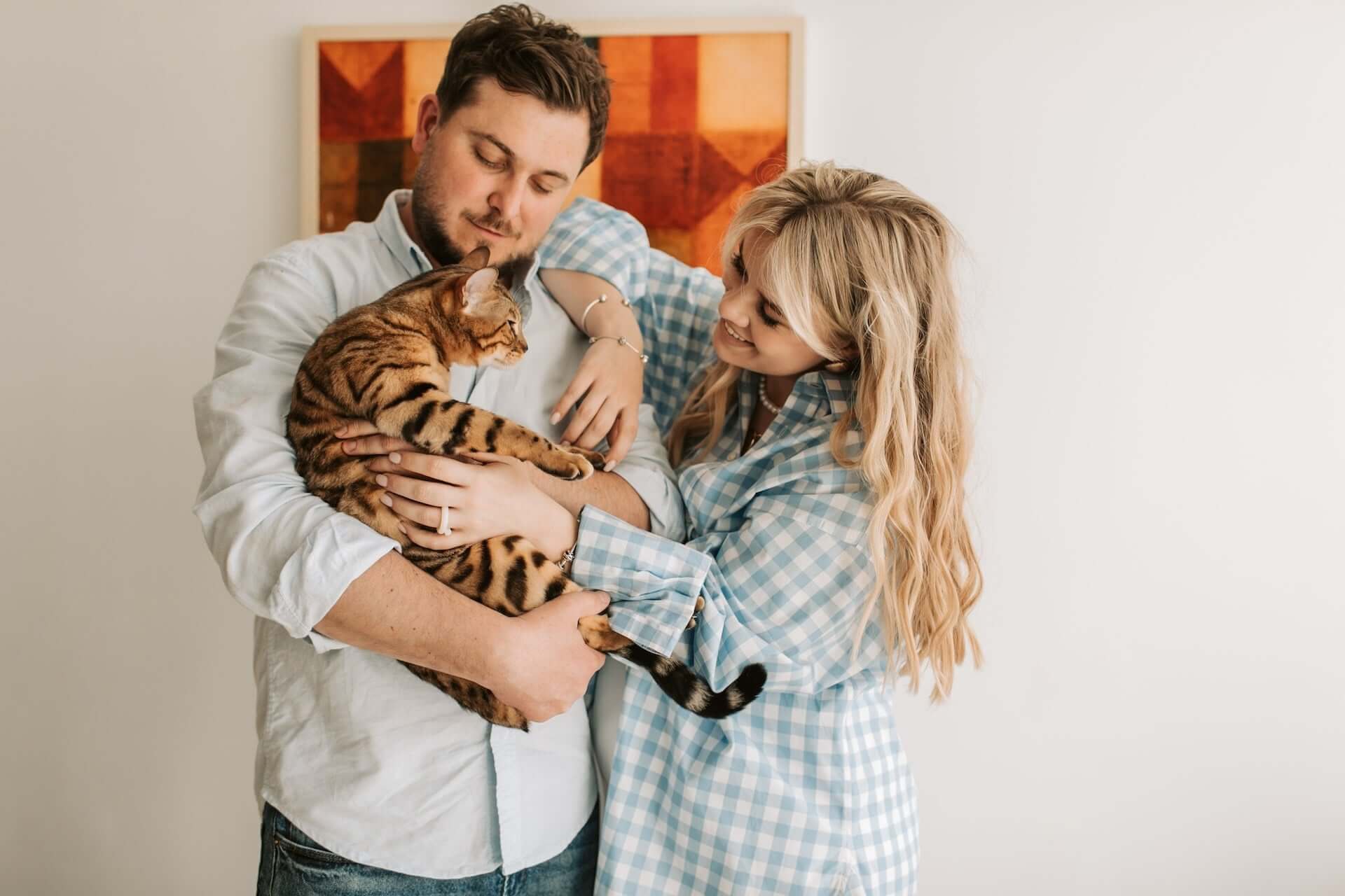 couple holding a bengal cat 