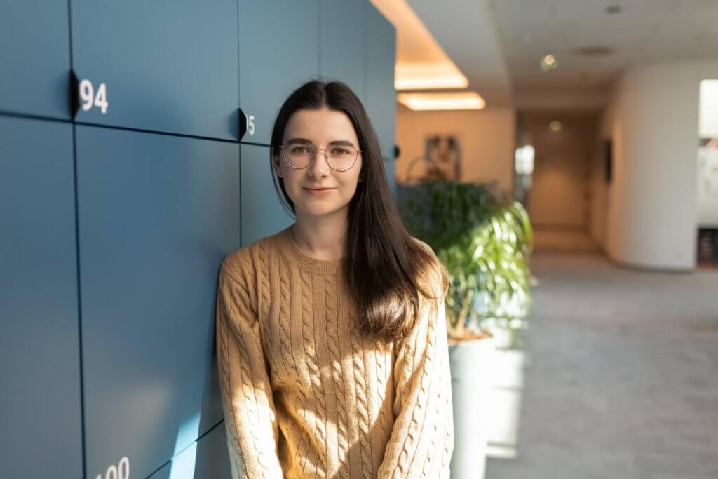 woman with glasses and brown hair standing in an office