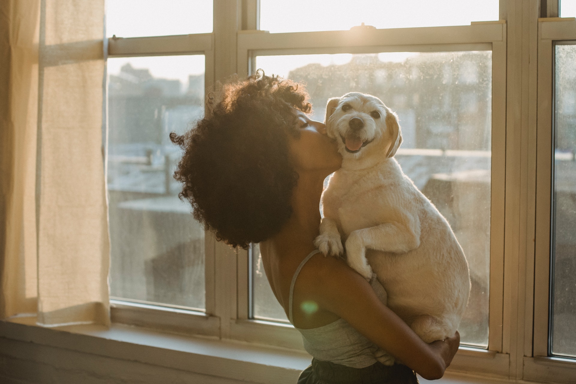 A woman hugging her dog indoors