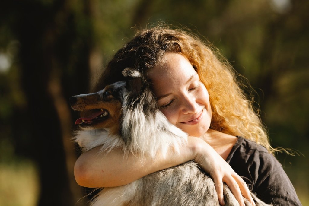 A woman hugging her dog outdoors