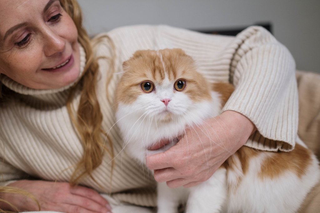 A woman hugging her cat on a bed