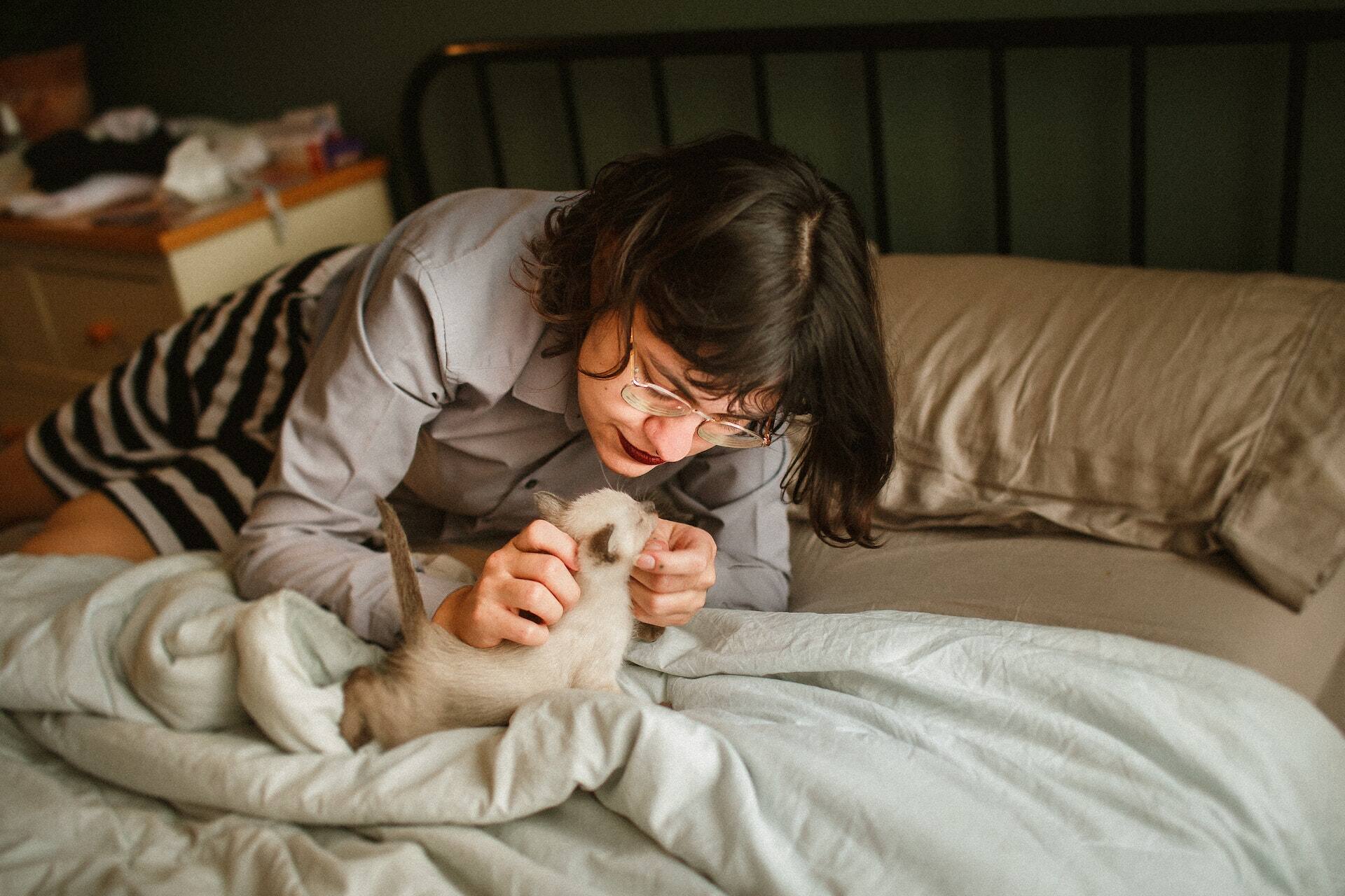 A woman cuddling a cat in bed