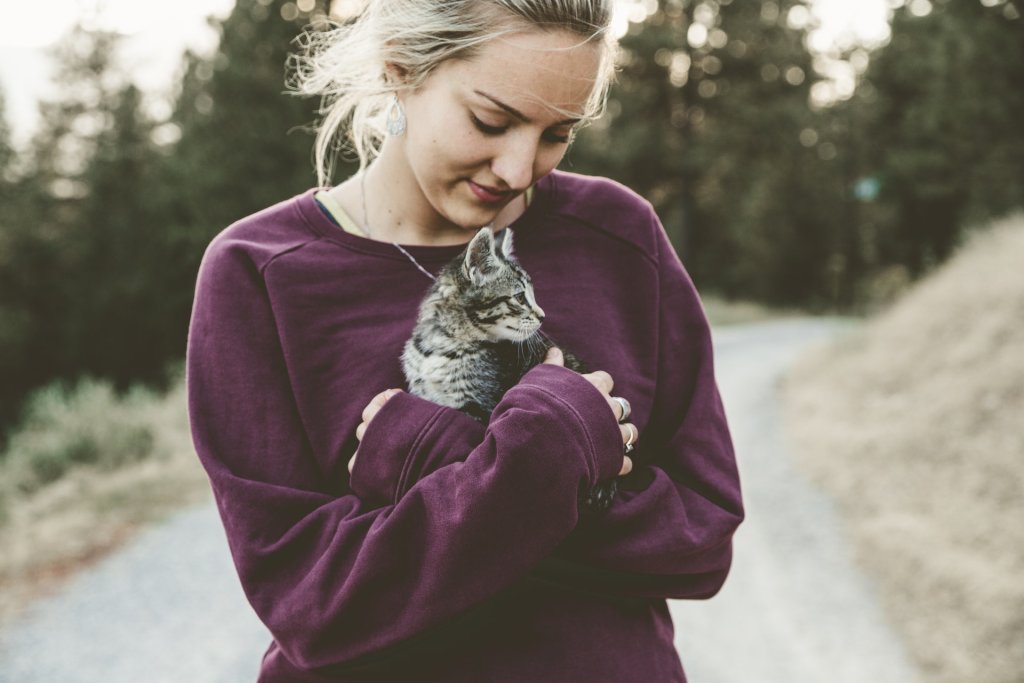 A woman holding her cat in her arms outdoors