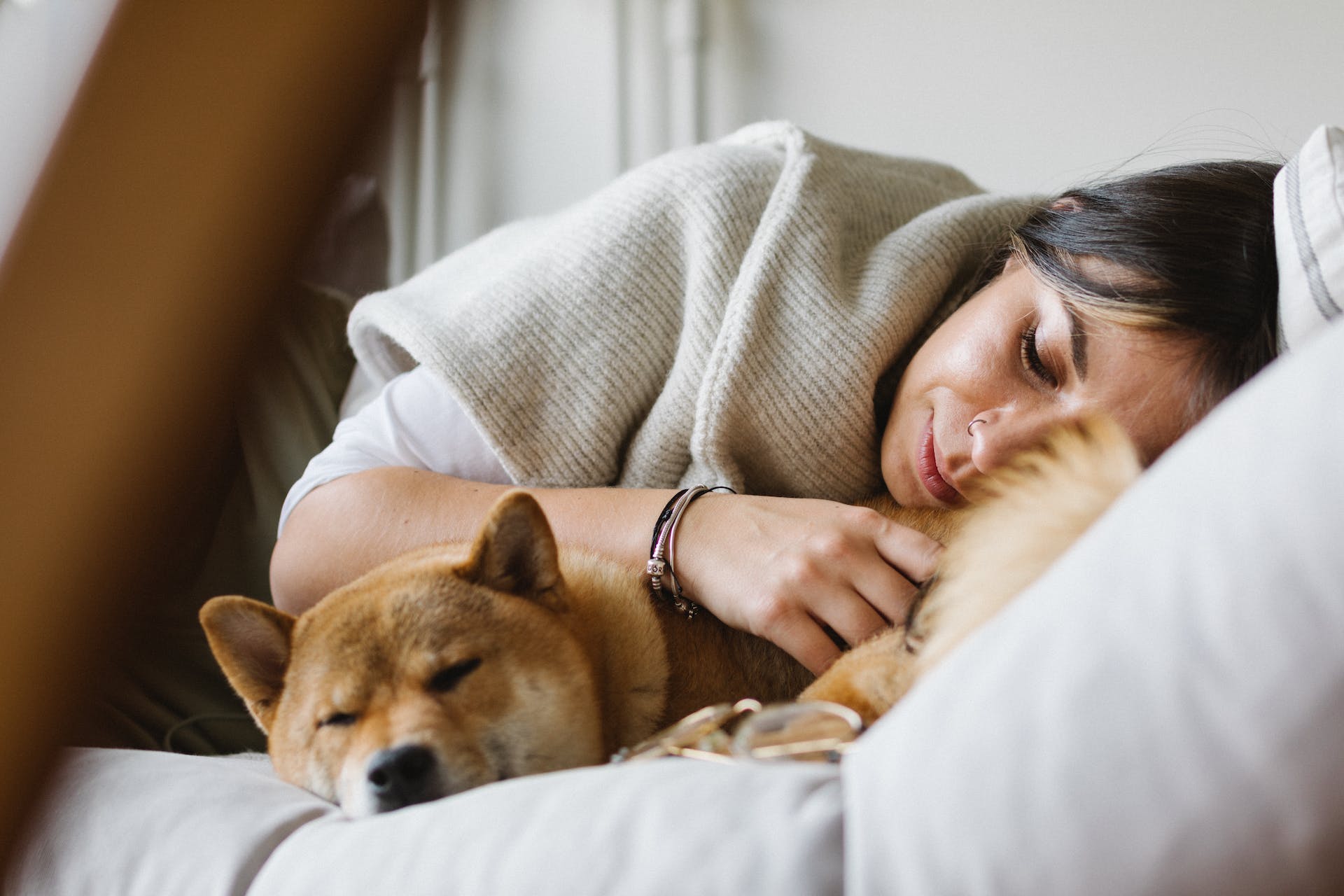 A woman lying in bed with a dog