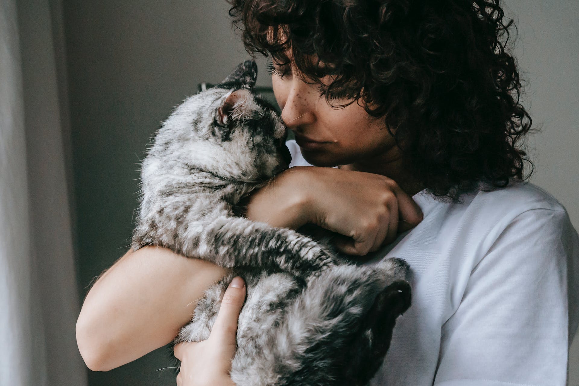 A woman hugging a cat indoors