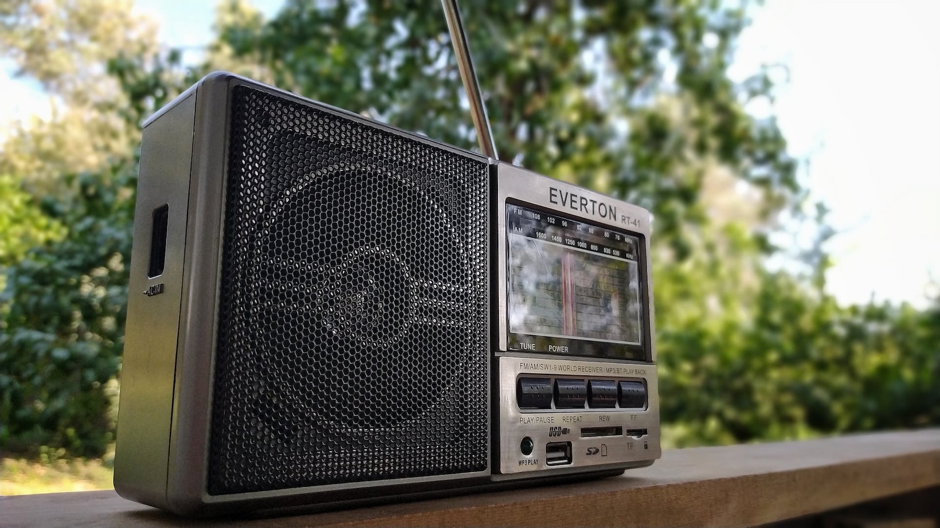 En radio placeret på en træhylde udendørs