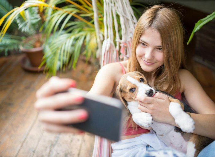 A girl taking a selfie with her puppy