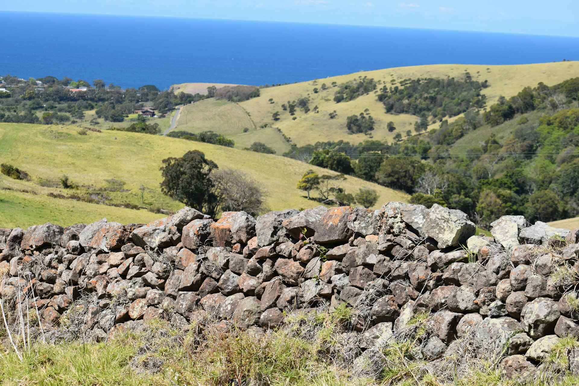 A stone fence overlooking a green hill