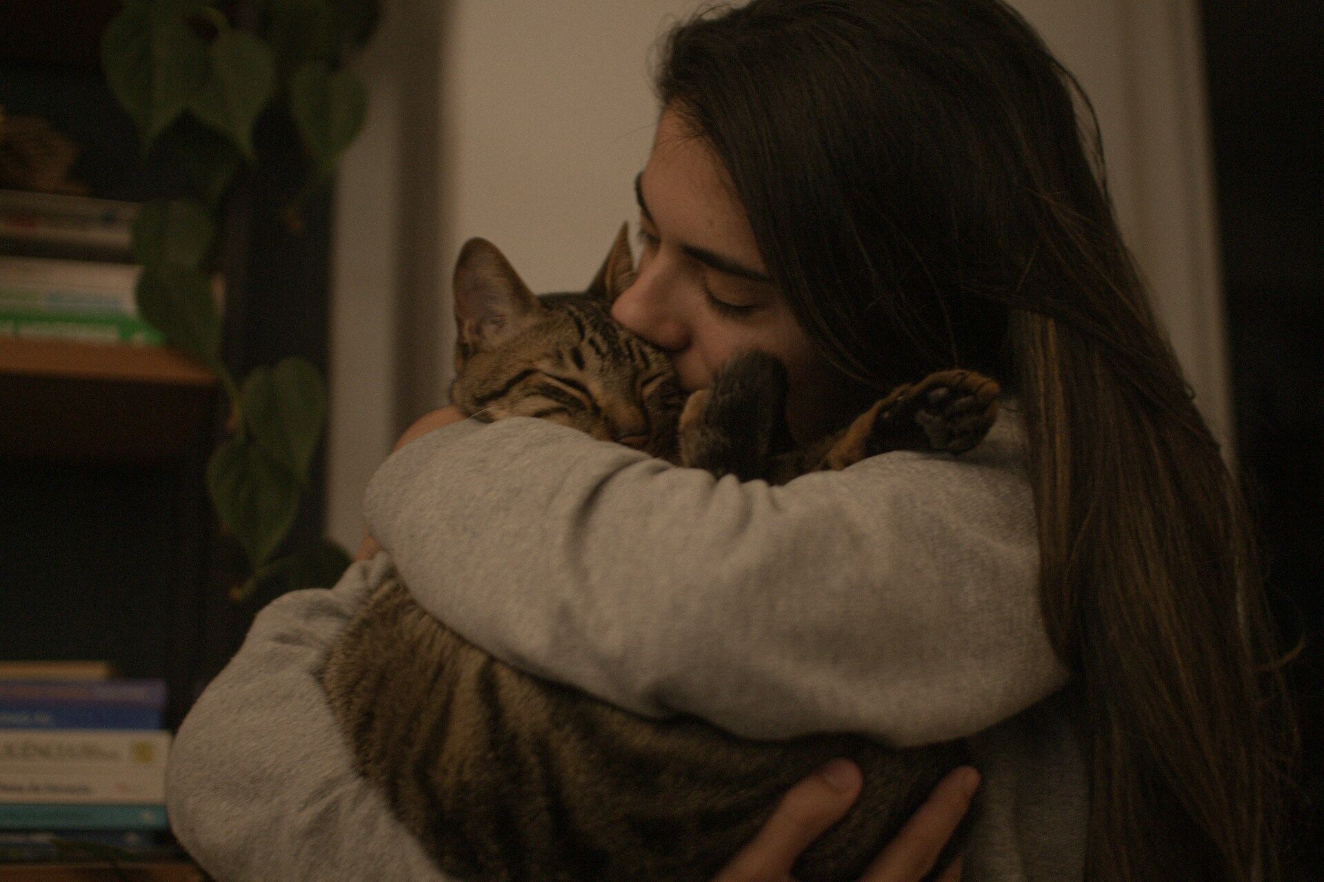 A woman hugging a brown cat