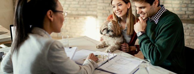 A young couple discussing pet insurance plans with an agent
