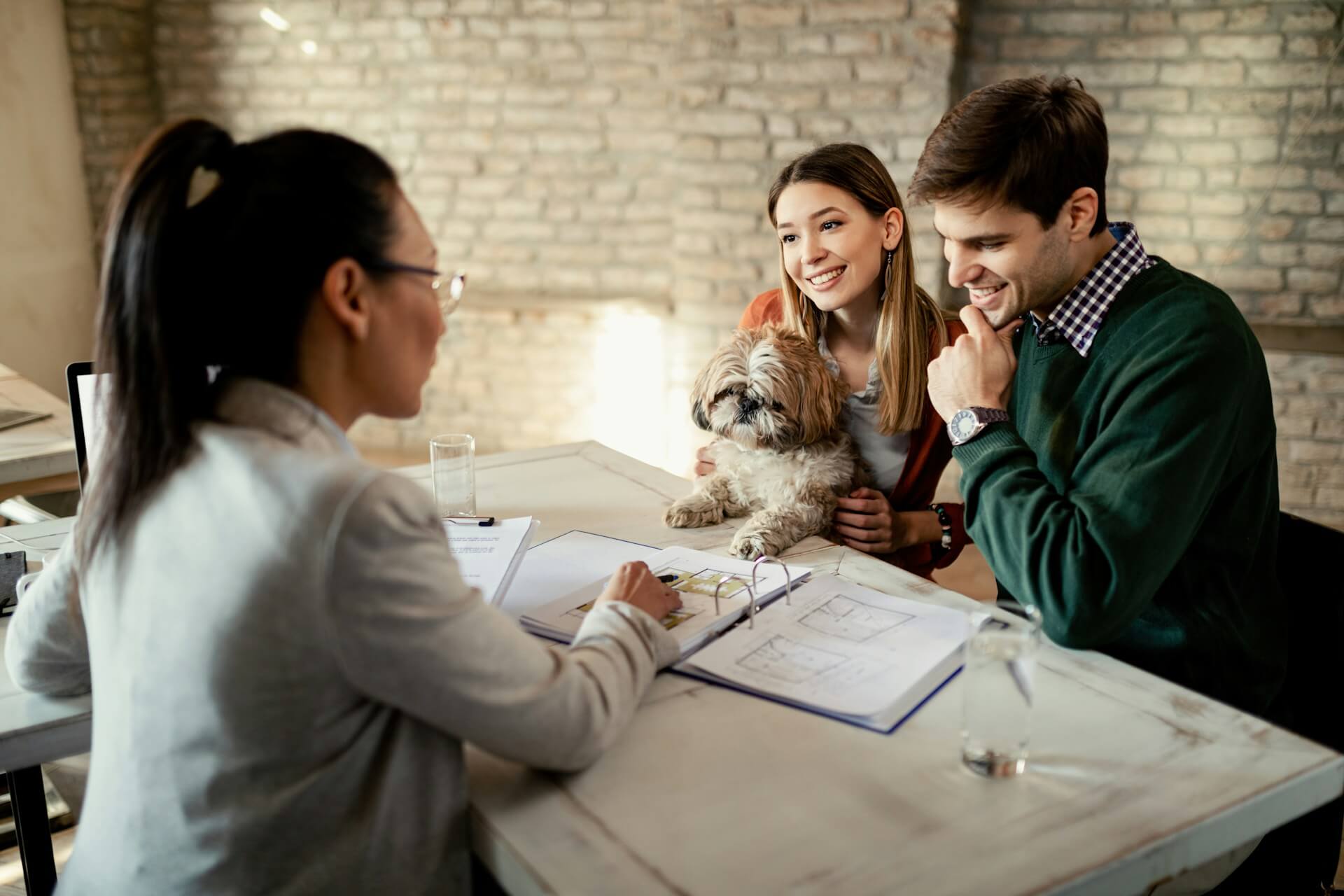 A young couple discussing pet insurance plans with an agent