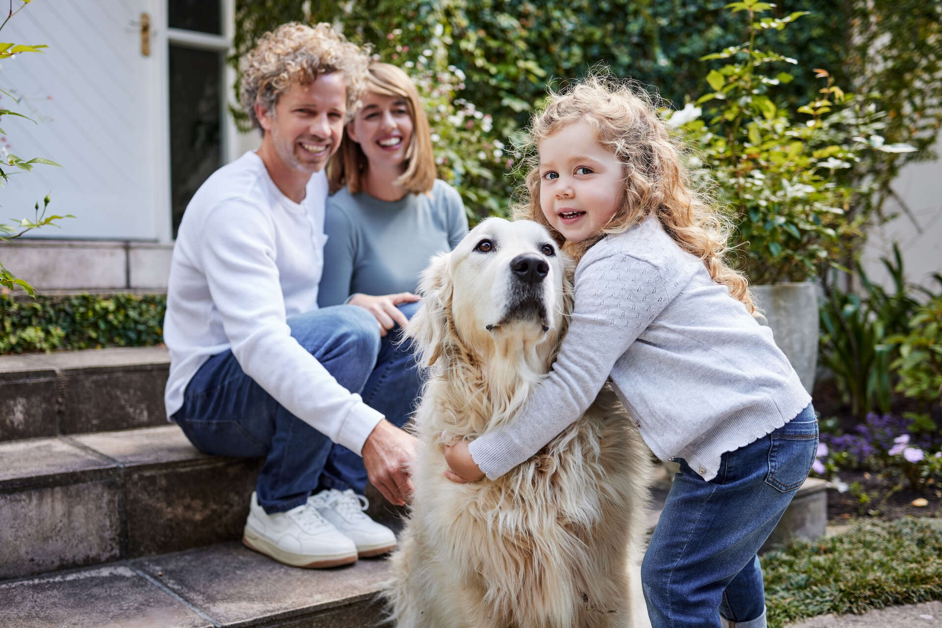 A family sitting with a Golden Retriever outdoors