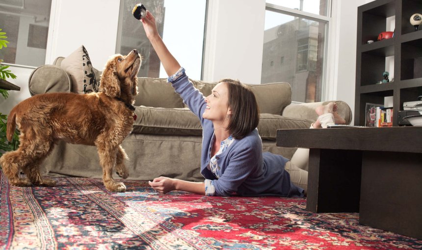A woman playing with her dog indoors