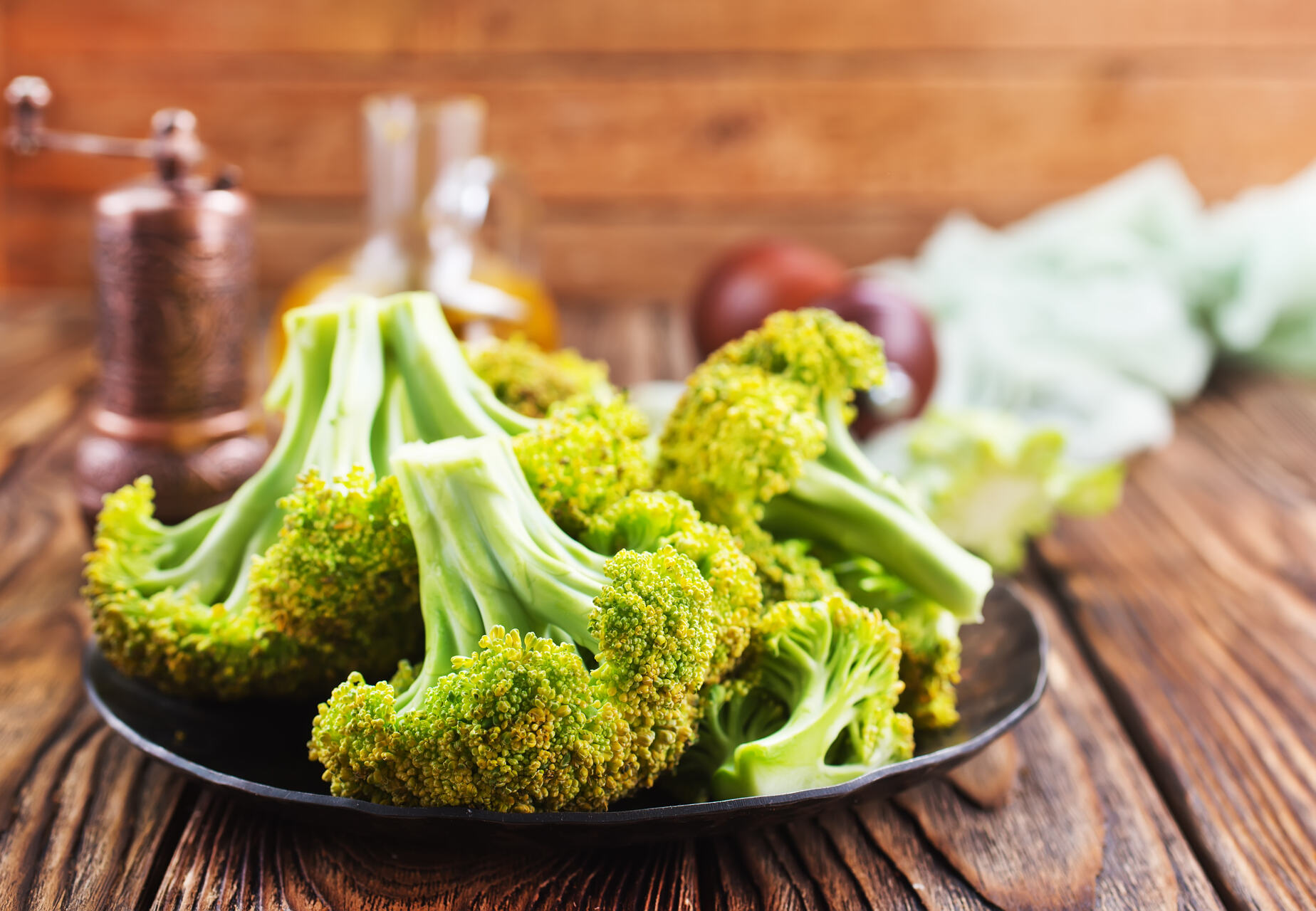 A plate of broccoli on a wooden table