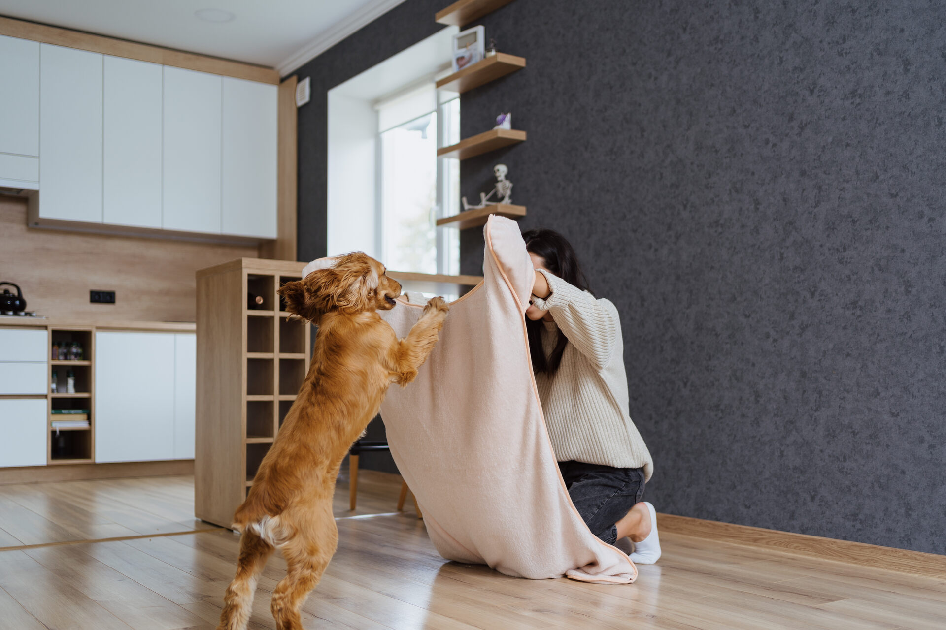 A woman playing with her dog indoors