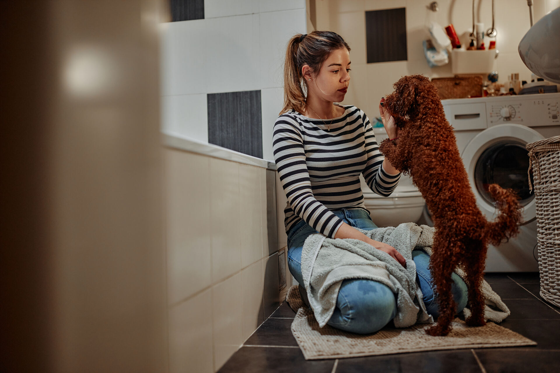 A woman training her puppy to go on toilet breaks indoors
