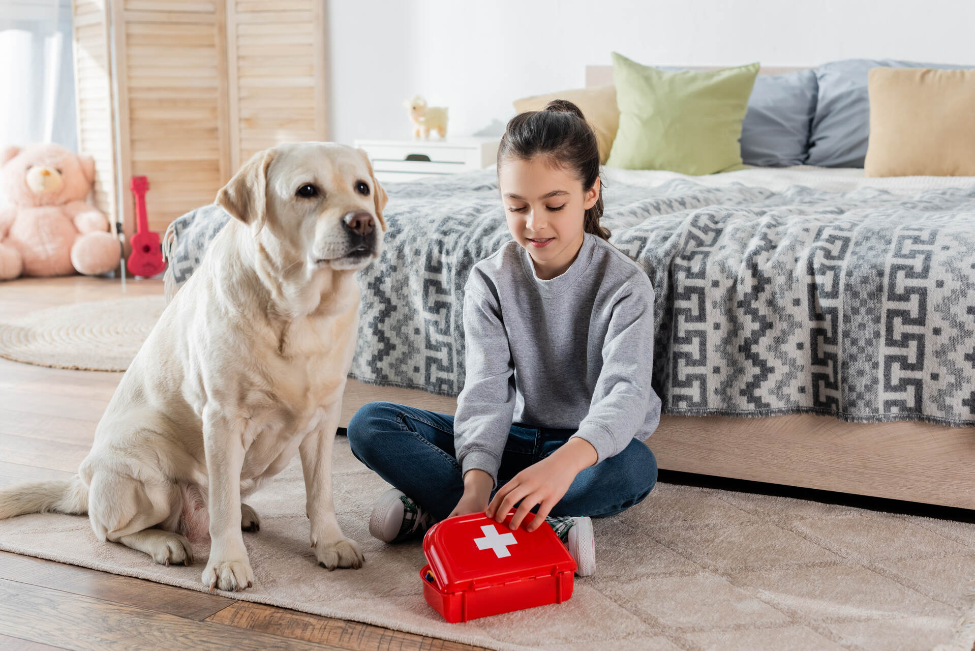 A young girl preparing a dog first aid kit at home