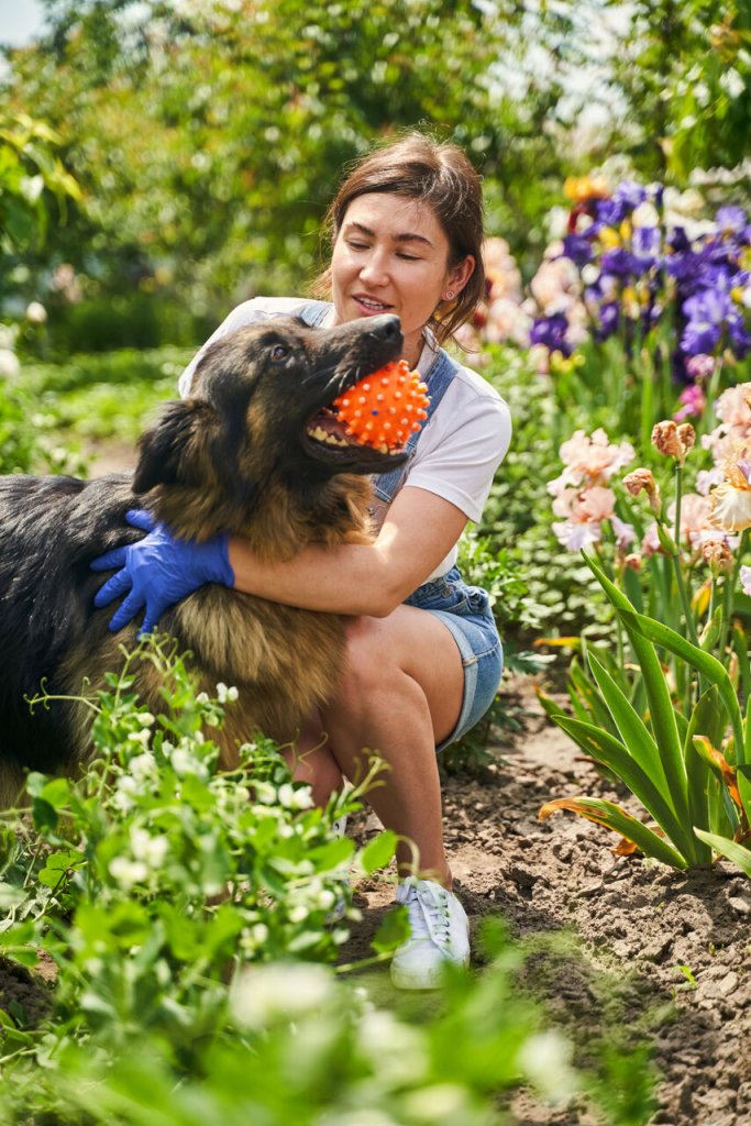A woman gardening with her dog