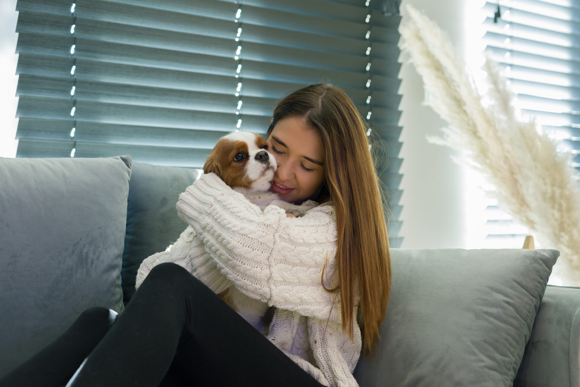 A woman hugging a dog on a sofa