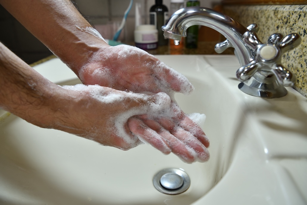 Mann wäscht sich die Hände mit Seife