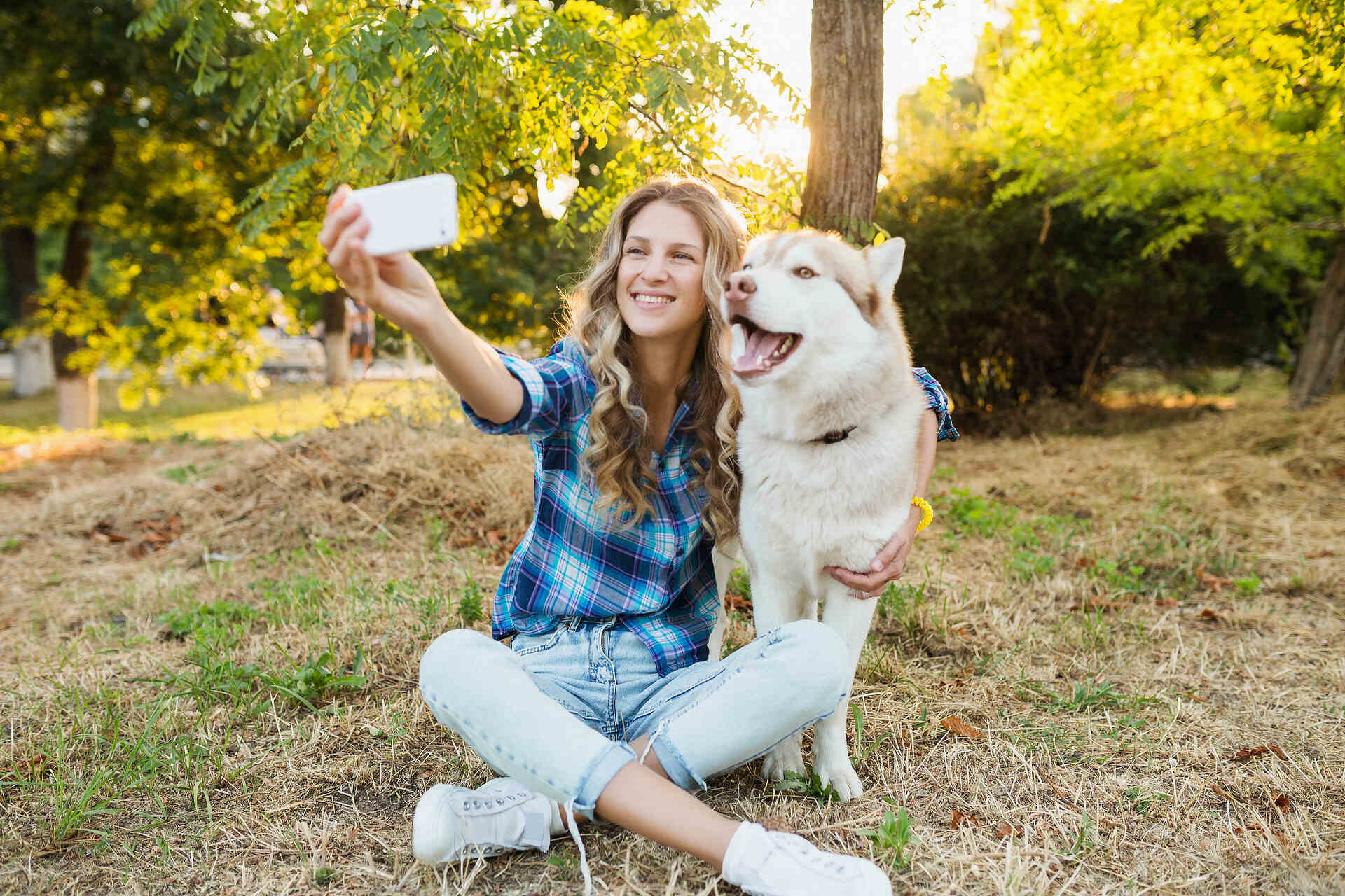 A woman taking a photo with her dog