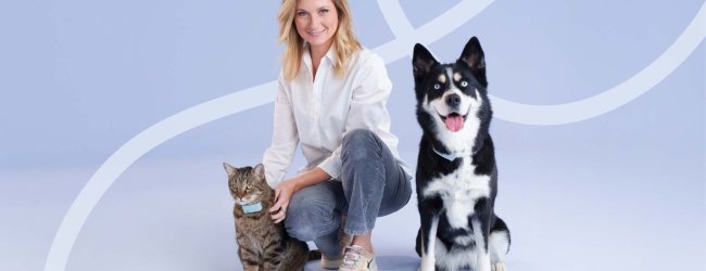 Sandrine Arcizet poses with a cat and dog wearing Tractive GPS trackers.